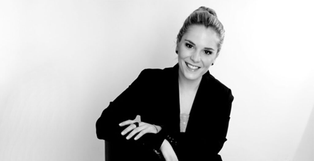 NDR 1 Moderatorin Isabel Eulenstein im schwarzen Jacket auf einem Stuhl sitzend