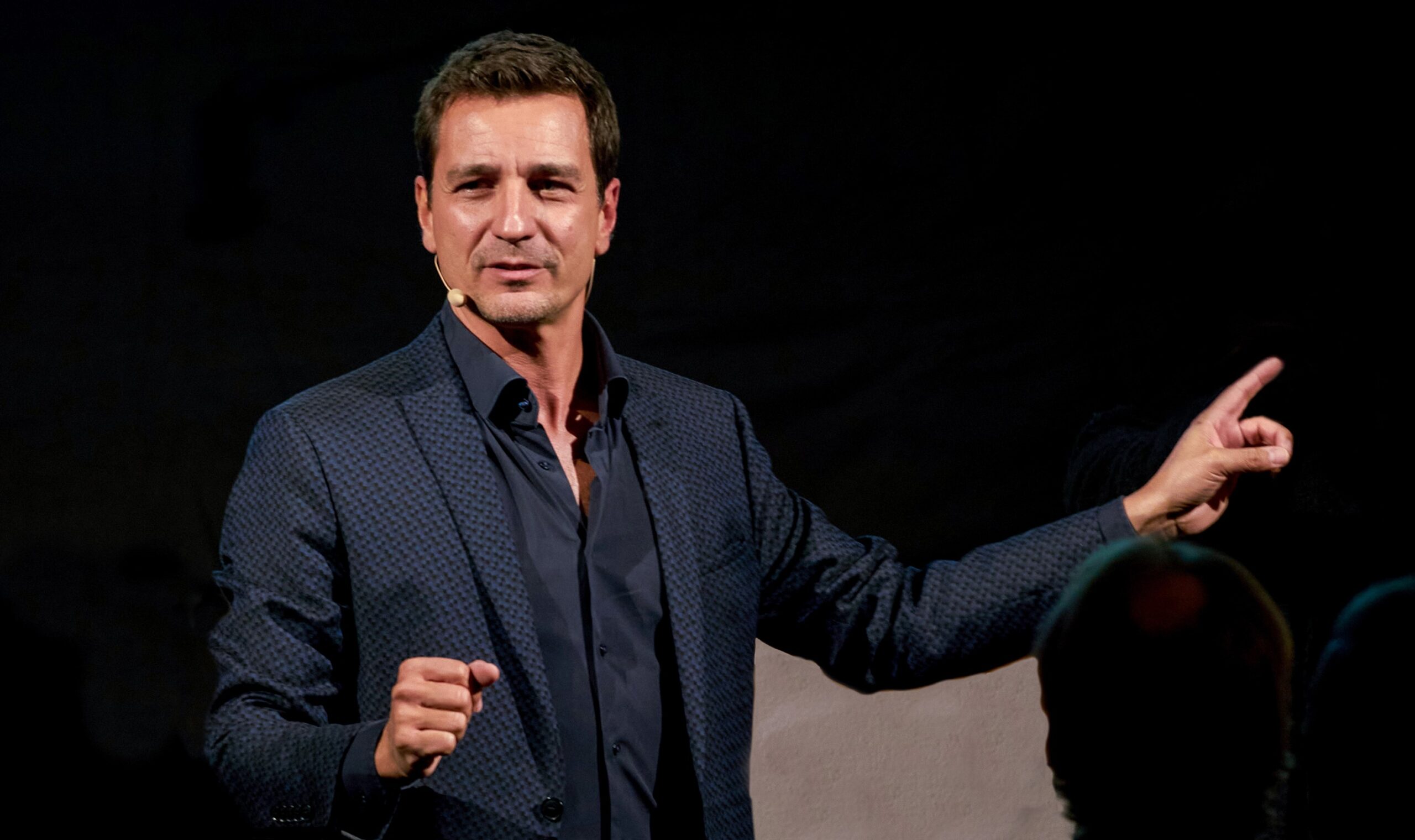 Moderator Thorsten Havener moderiert im blauen Anzug und blauem Hemd